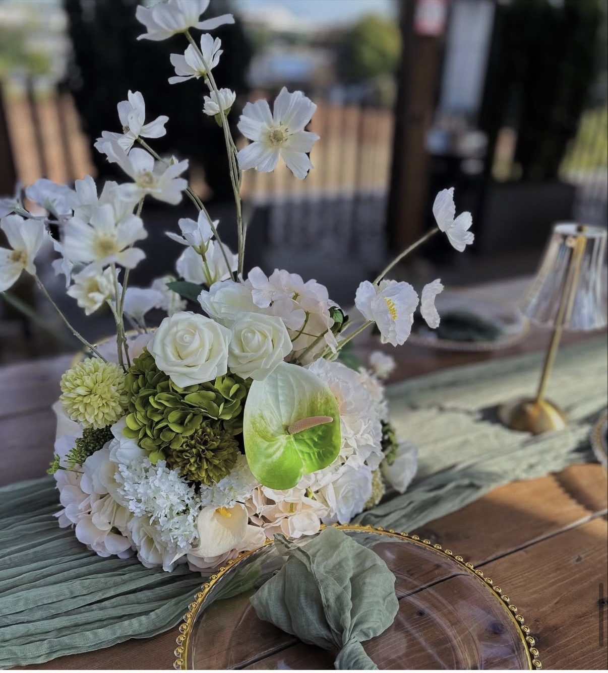White and sage silk floral centerpiece on gold charger tablescape — event styling Lower Mainland